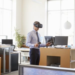 Businessman using VR technology in an office, side view Businessman using VR technology in an office, side view